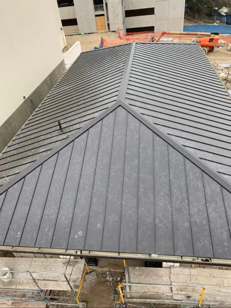 Commercial metal roof construction with crane equipment in Traverse City