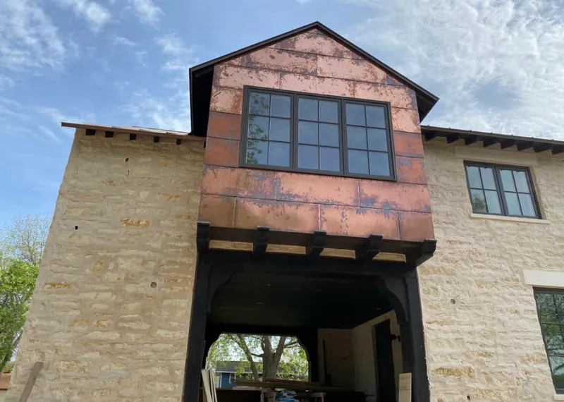 Copper metal panel facade on a stone building for Metal Roof Coating in Traverse City
